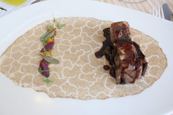 Choto al ajillo con suelo de hueso de aceituna y frutos secos